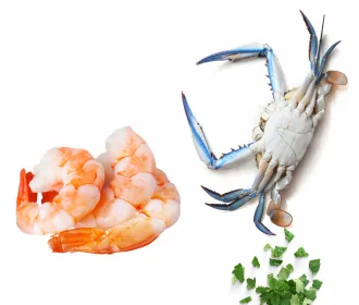 Cleaned peeled prawns next to a whole blue crab with shell
